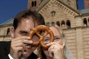 Brautpaar vor Speyerer Dom schaut durch eine Brezel