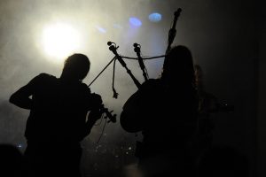 Geieger und Dudelsackspieler im Gegenlicht vom Hintergrund der Bühne gesehen