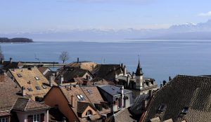 Blick über Uferhäuser in Nyon auf den Genfer See