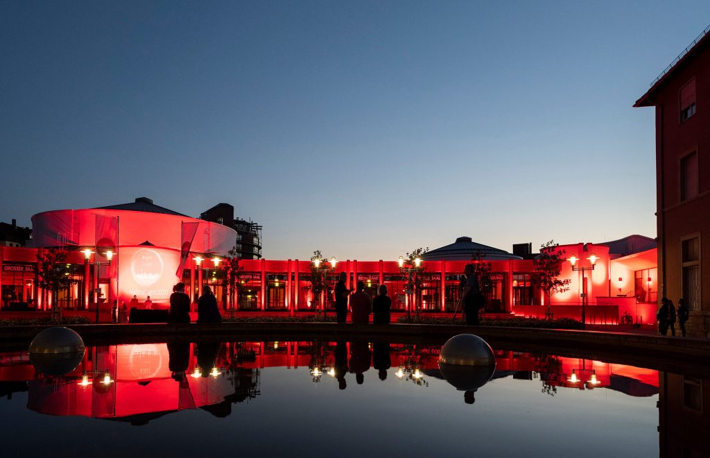 Rot beleuchtetes Congress Forum Frankenthal spiegelt sich im Wasserbecken