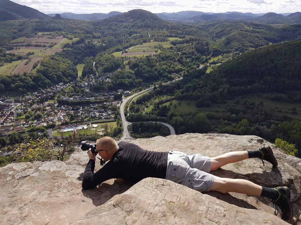 Fotograf Klaus Venus während einer Wanderung auf dem Sommerfels bei Annweiler liegend