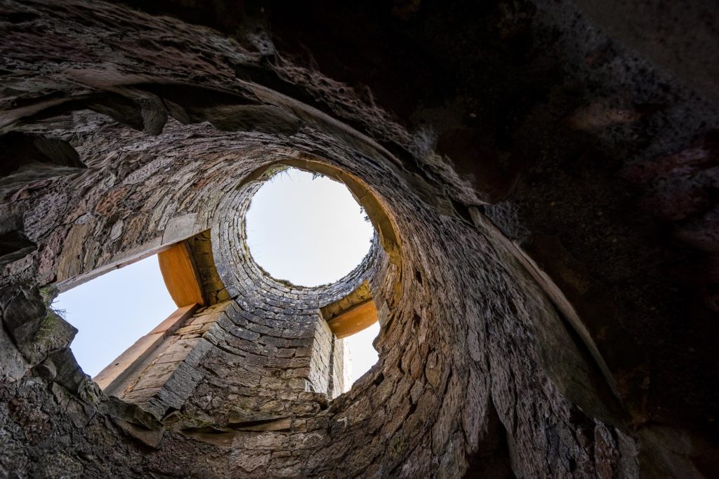 Blick vom Boden der nur noch aus Außenamuern bestehenden Turmruine direkt nach oben in den Himmel