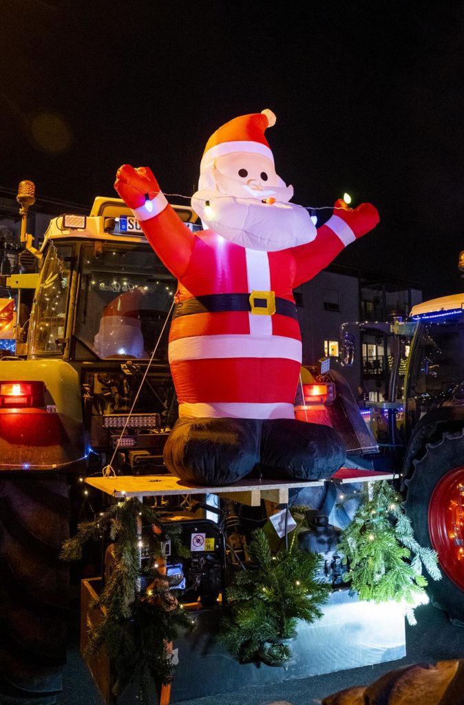 Mit riesigem aufblasbaren Weihnachtsmann geschmückter Traktor
