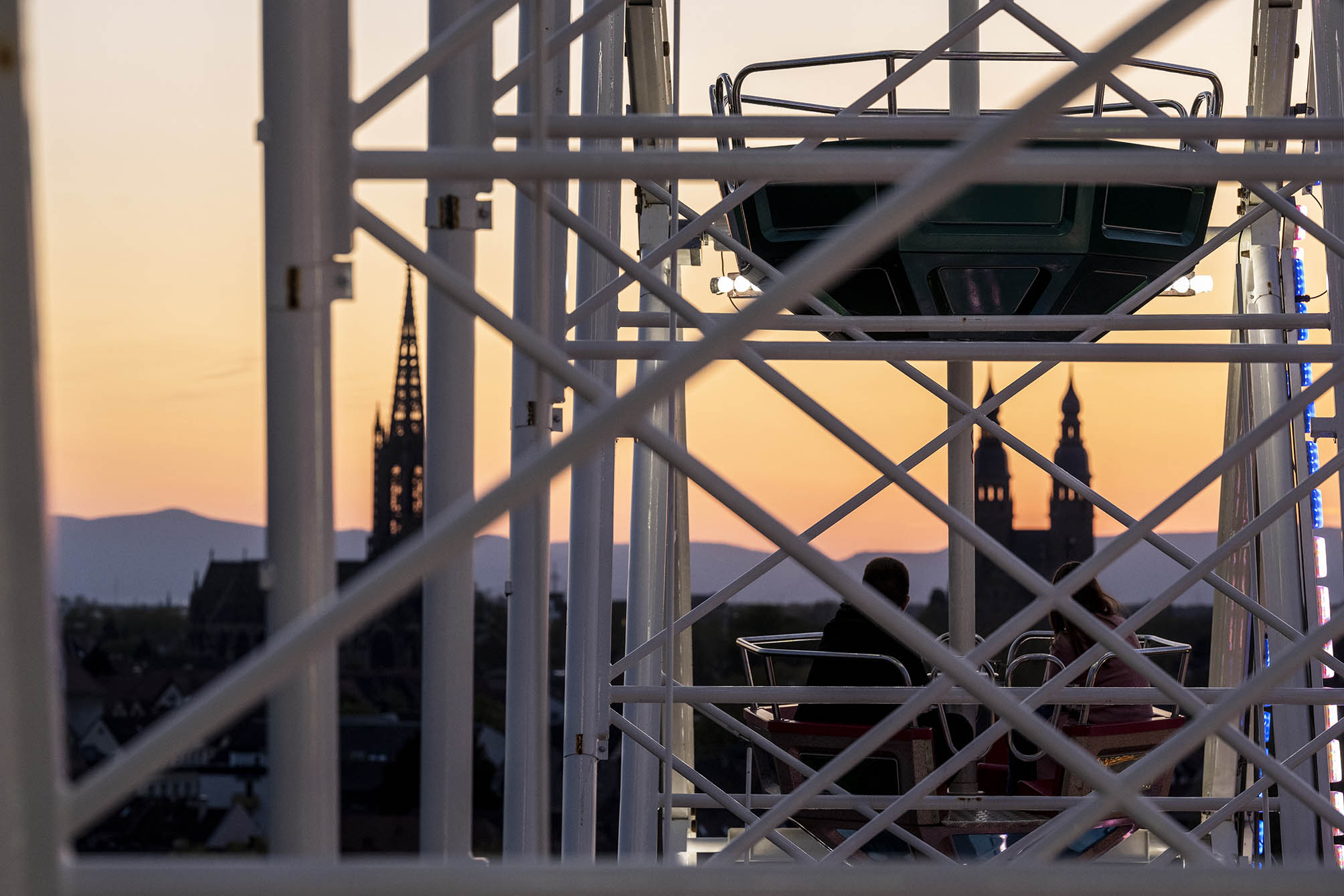 Blick aus dem Riesenrad Richtung Haardt mit Silhouetten der Gedächtniskirche und St.Joseph vor Sonnenuntergang