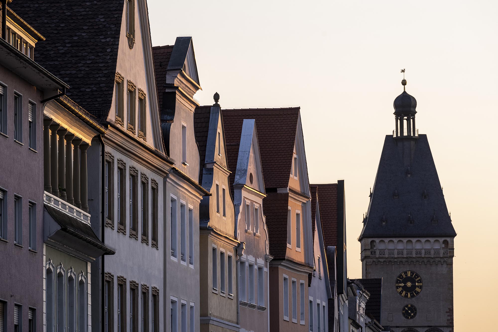 Impression in der Abenddämmerung von der Speyerer Innenstadt im Bereich Maximilianstrasse. Hier der Blick Richtung Westen im Sonnenuntergang auf die schön von der Abendsonne angestrahlten Patrizierhäuser und das Altpörtel