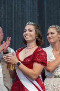 Die neue Brezelkönigin Lea Leddin, im Hintergrund ihre Vorgängerin Anne-Susann Sperling, von der sie die Krone bekommen hat.