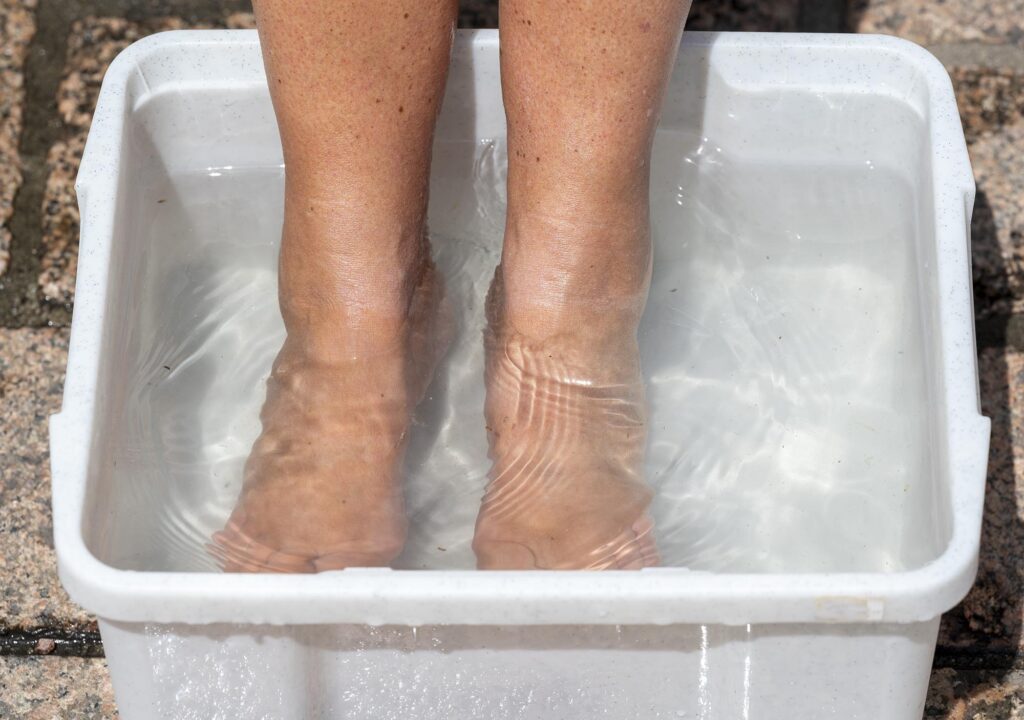 Füße in einer Wanne Wasser, die offenbar ein Zuschauer mitgebracht hat