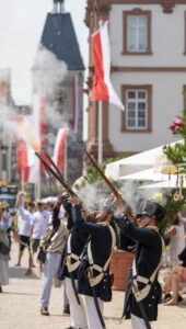 Die Bürgergarde Speyer schiesst mit rauchenden Gewehren einen lautstarken Salut