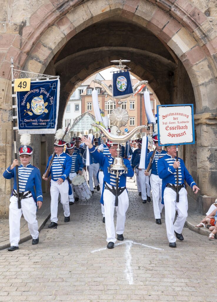 Der Spielmannszug der königlich bayerischen Landwehr Esselbach mit seinen blauweißen Uniformen ändert mal kurz die Zugroute und läuft durchs Altpörtel