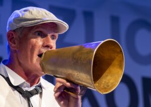 Großaufnahme von Horst Aussenhof mit weißer Mütze und goldener Flüstertüte