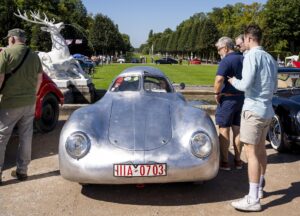 Mehrere sommerlich gekleidete Männer betrachten einen VW 60K10 oder Porsche 64K10 mit silberner Aluminium-Karosserie von 1938