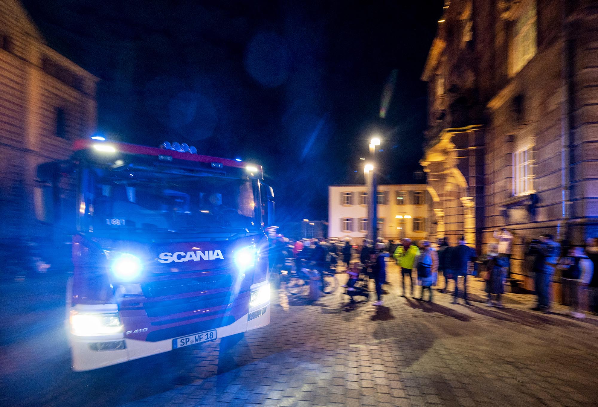 Bewegungsunscharfes Buld eines am Stasthausum die Ecke brausenden Feuerwehrautos