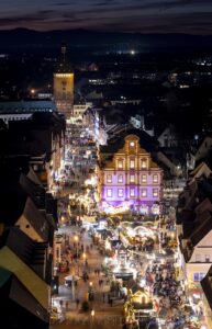Blick vom Dom über die beleuchtete Maximilianstraße bis hin zum Horizont, der mit dem Nachthimmel verschmilzt