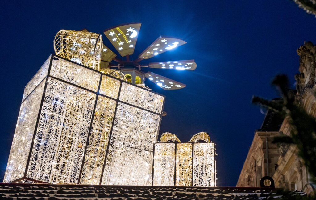 Große leuchtende Drahtskulturen in Geschenkform vor dem Stadthaus