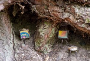 Miniatur-Maleratelier in einer Baumwurzel