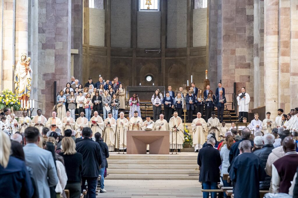 Pontifikalamt im Speyerer Dom vom Mottelgng zum Altar forografiert, Gläubige links und rechts, Priester und Gemeindechöre im Altarraum