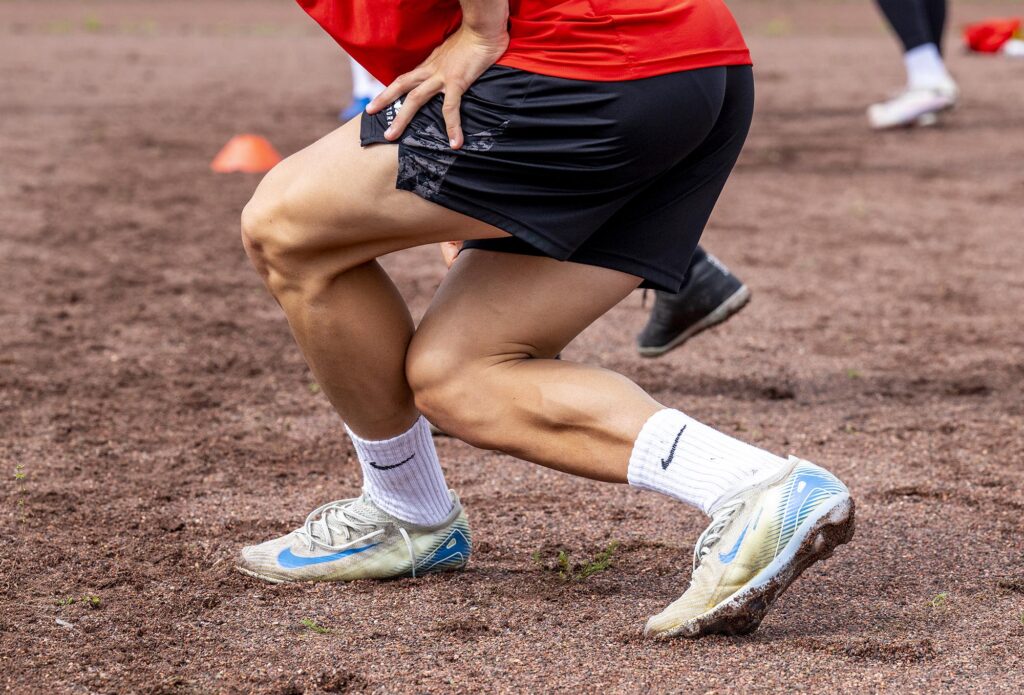 Großaufnahme arbeitender Beinmuskeln beim Training auf dem Sandplatz