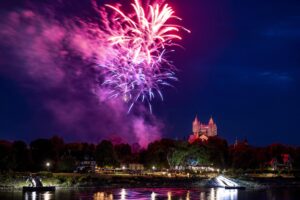 pink und lila Feuerwerk über dem Domgarten, Rheinufer im Vordergrund