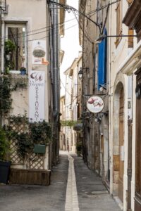 Enge Gasse mit verschiedenen Restaurant- und Ladenschildern