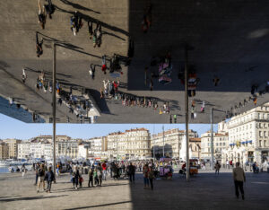 Menschen am Hafen von Marseille werden über Kopf in der Spiegelinstallation Ombrière de Norman Foster reflektiert