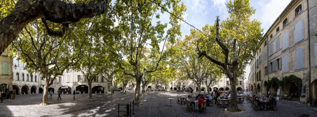 Panoramafoto eines Marktplatzes Place aux Herbes mit Bäumen und Cafés