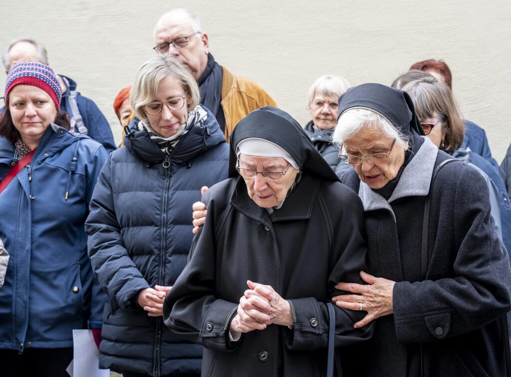 Am Anwesen Judengasse 9 wird Karl Weinmann gedacht. Schwester Roswitha Weinmann ist eine Schwester des Opfers und legt eine Rose nieder (rechts neben ihr eine Mitschwester)