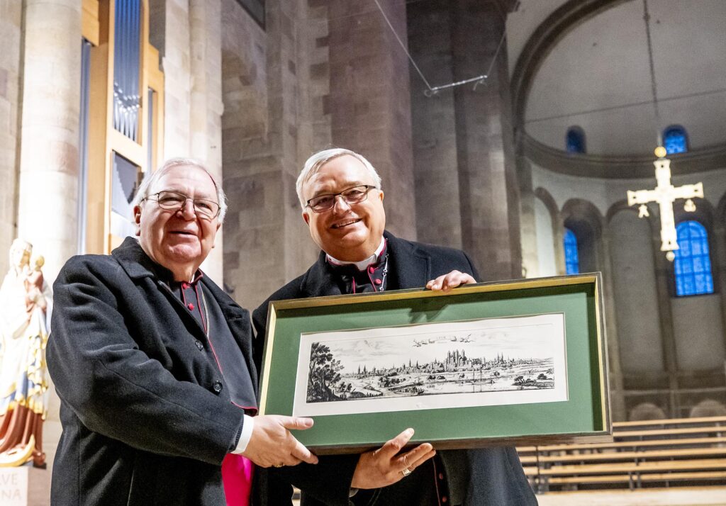 Bischof Dr. Karl-Heinz Wiesemann überreicht ein Geschenk an Georgens