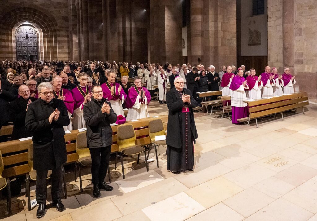 Stehender Applaus für Georgens (Blick schräg über das voll besetzte Mittelschiff mit Portal im Hintergrund)