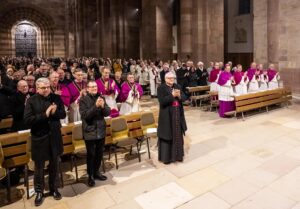Stehender Applaus für Georgens (Blick schräg über das voll besetzte Mittelschiff mit Portal im Hintergrund)