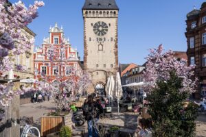 Postplatz mit Kirschbäumen und Cafésitzen mit Blick aufs Altpörtel