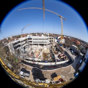 Blick von einem Baukran auf die komplette Baustelle. Eine Aufnahme mit dem Fisheye-Objektiv