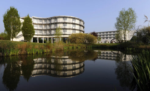 Tagungsgebaeude und Gaestehaus der Deutsche Hochschule fuer Verwaltungswissenschaften, DHV, im Sonnenaufgang in einer Spiegelung in einem Teich