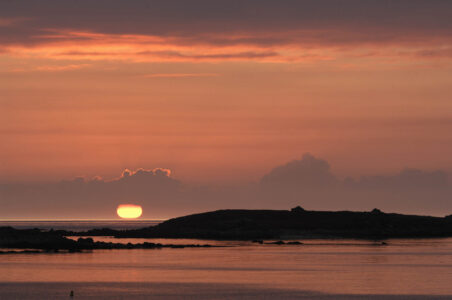 Sonnenuntergang am Strand, glutrot versinkt die Sonne im Meer