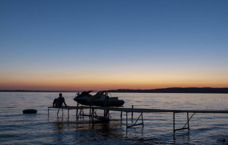Sonnenuntergang am Lake michigan mit Steg und Boot im Vordergrund