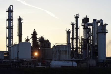 Sonne geht hinter Industrieanlagen auf