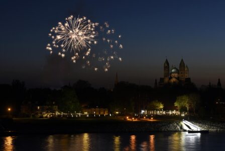 Blick auf Speyer bei Nacht von der anderen Rheinseite, links Feuerwerk, rechts der Dom